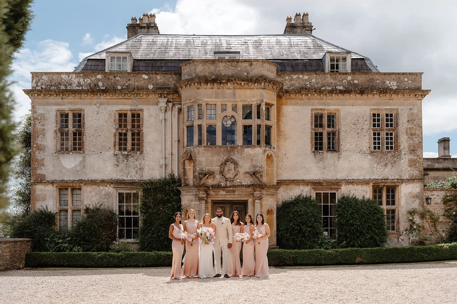 Hamswell House wedding venue exterior with bridal party holding pastel bouquets near Bath