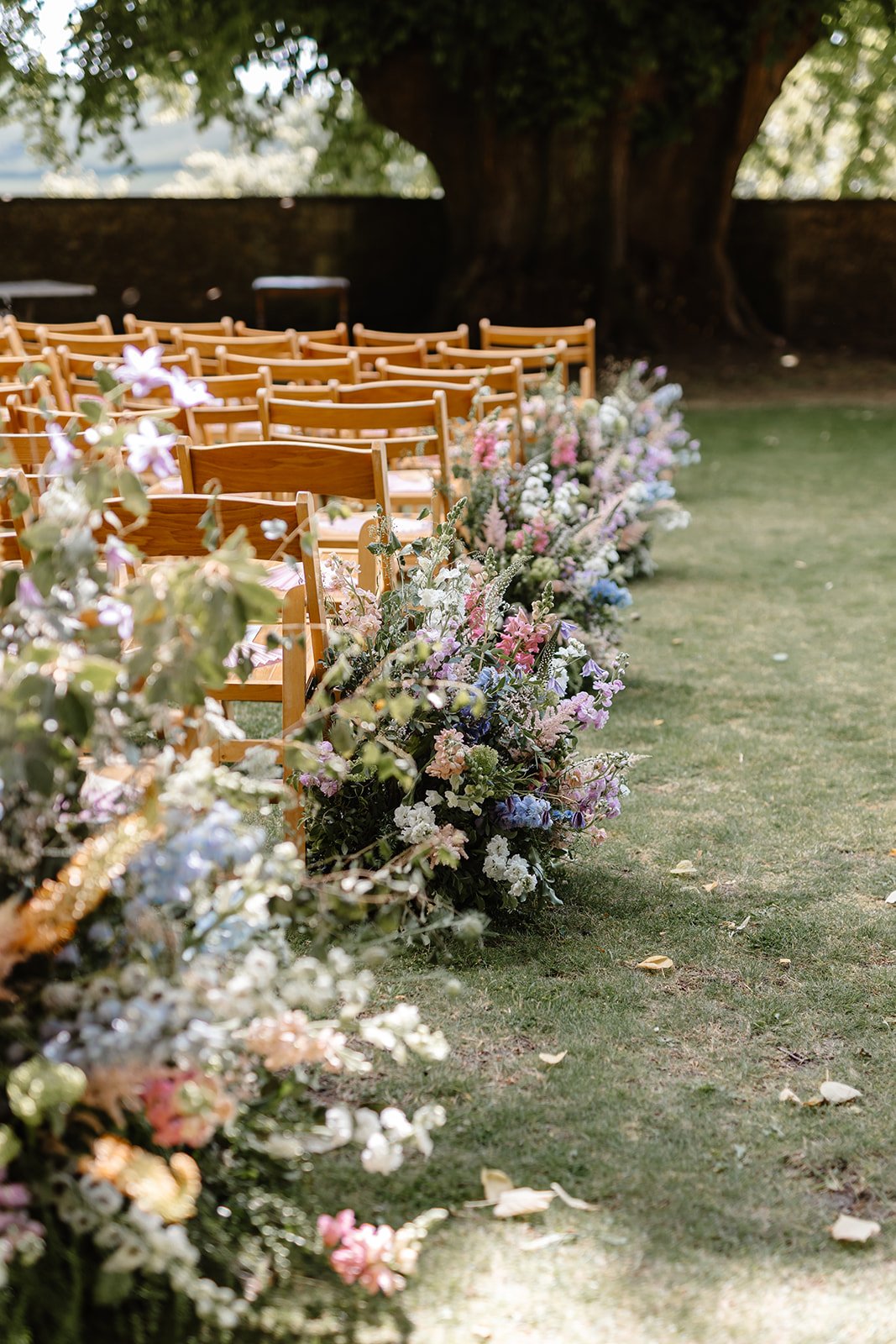 Outdoor ceremony aisle meadows at Hamswell House in Bath featuring astilbe, stocks, delphinium, eremurus, clematis and nigella beneath the ancient lime tree.