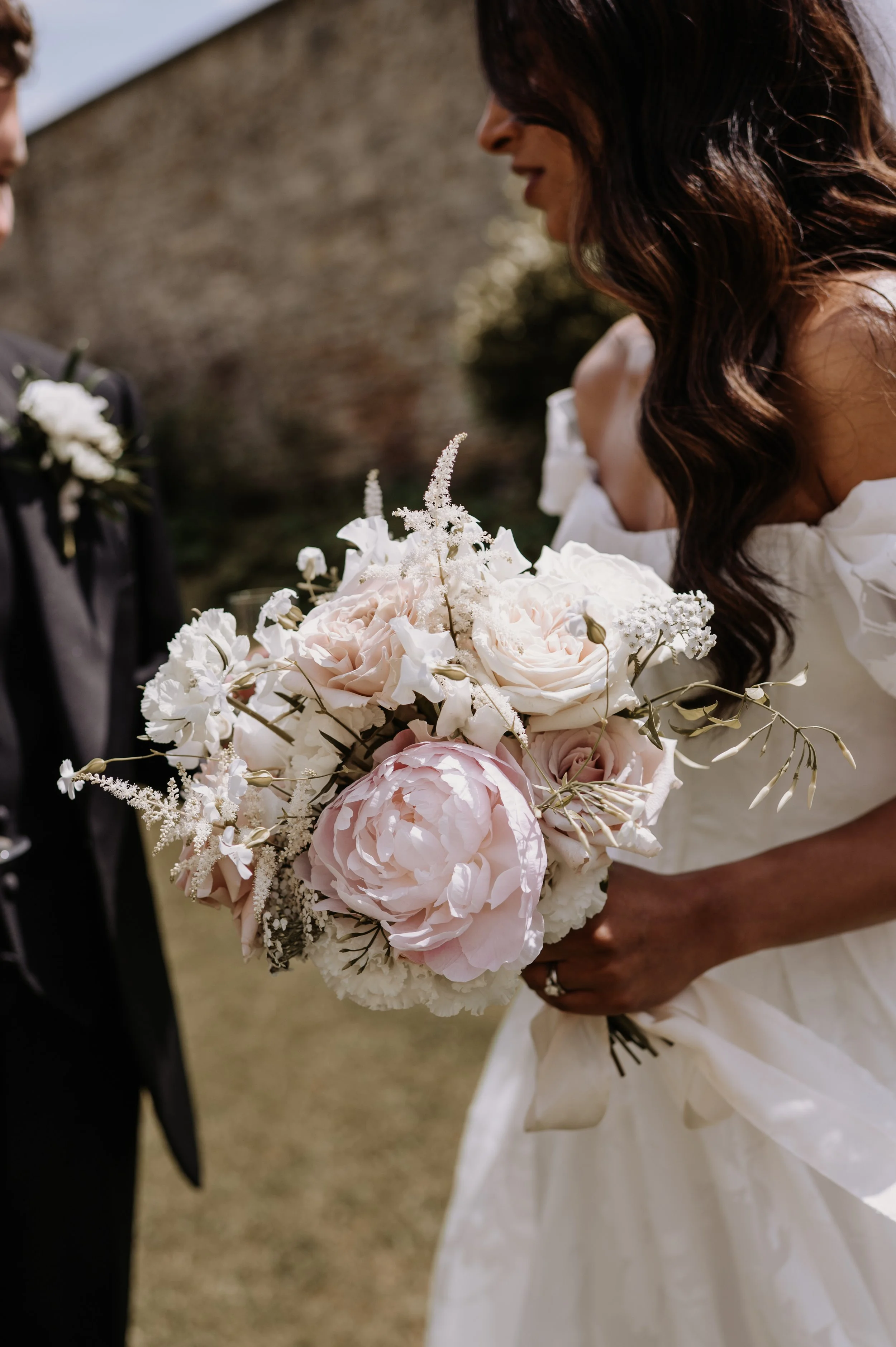 Bridal bouquet for a wedding at Farleigh House, Farleigh Hungerford, featuring Westminster Abbey roses, white Madame Claude Tain and Chiffon Parfait peonies, jasmine vine and soft pink astilbe.