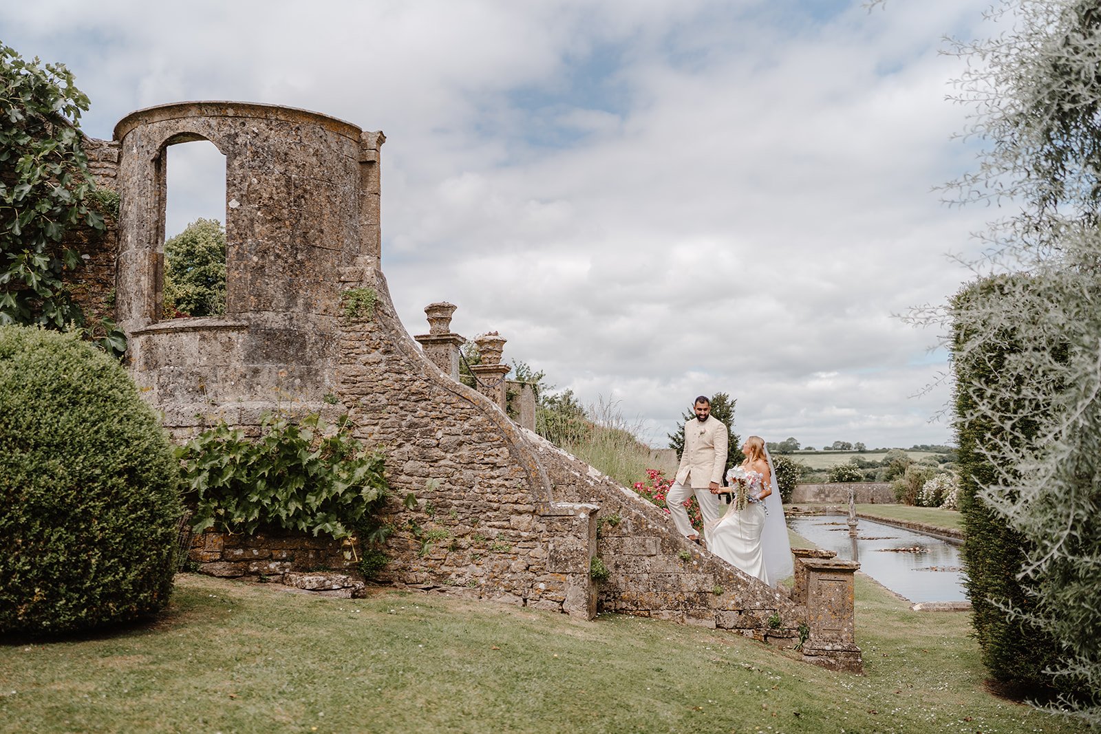 Wedding couple portrait on the stone steps at Hamswell House in Bath overlooking the Somerset countryside