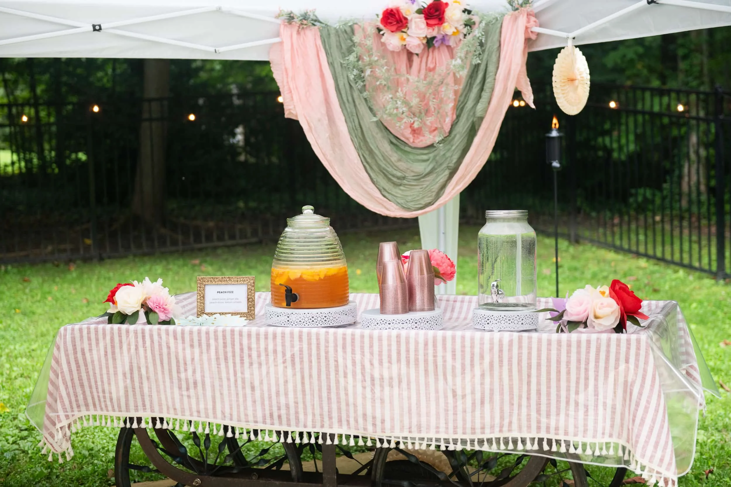 Champagne Quarters mobile bar offers an antique cart rental for a few beverage dispensers and cups with flowers decorating it.