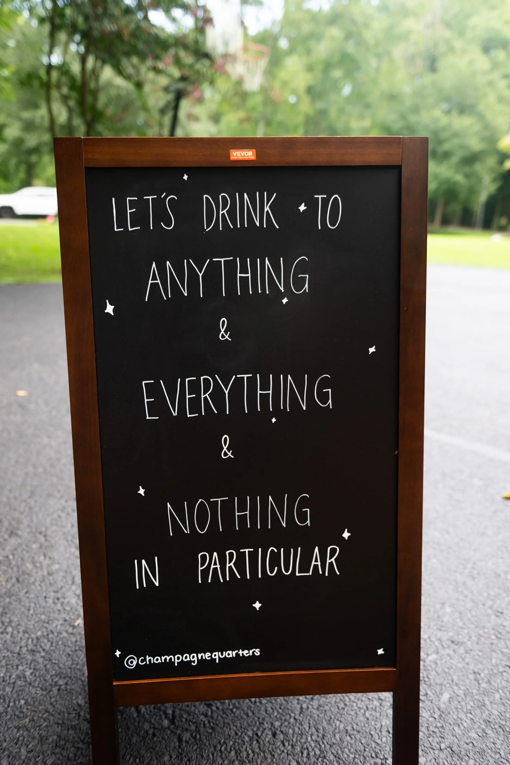 Champagne Quarters mobile bar A-frame sign showing fun quote for serving all events.