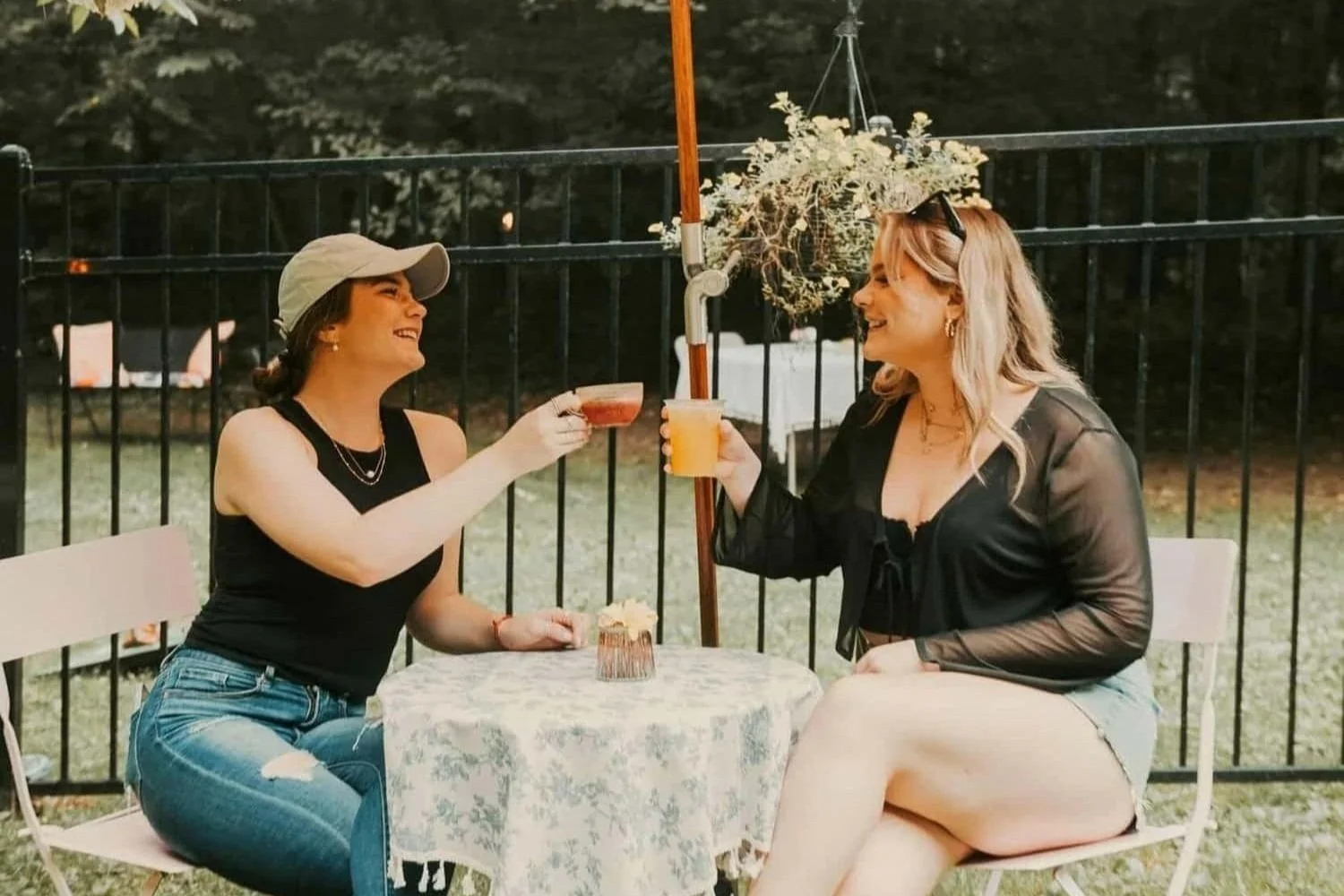 Champagne Quarters horse trailer mobile bar served 2 young women delicious cocktails in garden style private party.