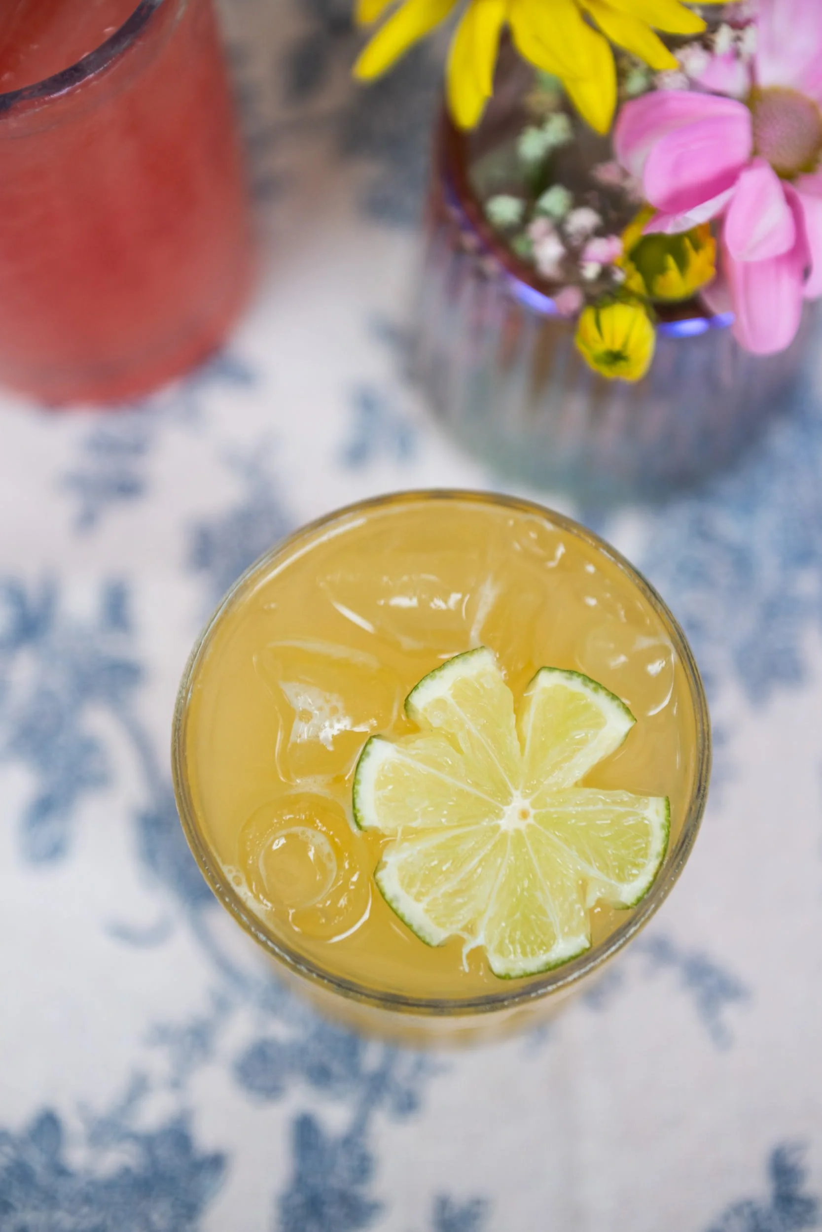 Champagne Quarters mobile bar serving a peach margarita cocktail with a lime cut into a flower as a garnish.