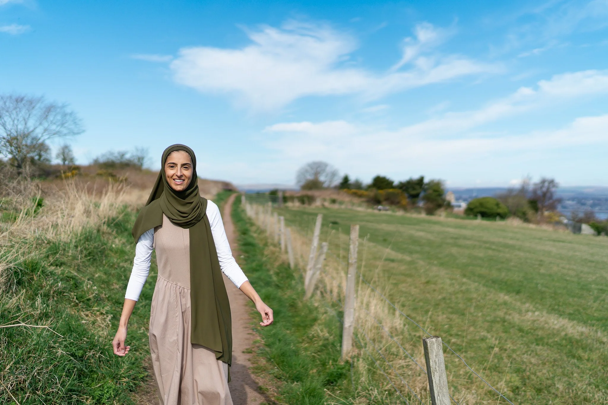 dietitian photographed walking through lovely green field on a sunny day in Scotland