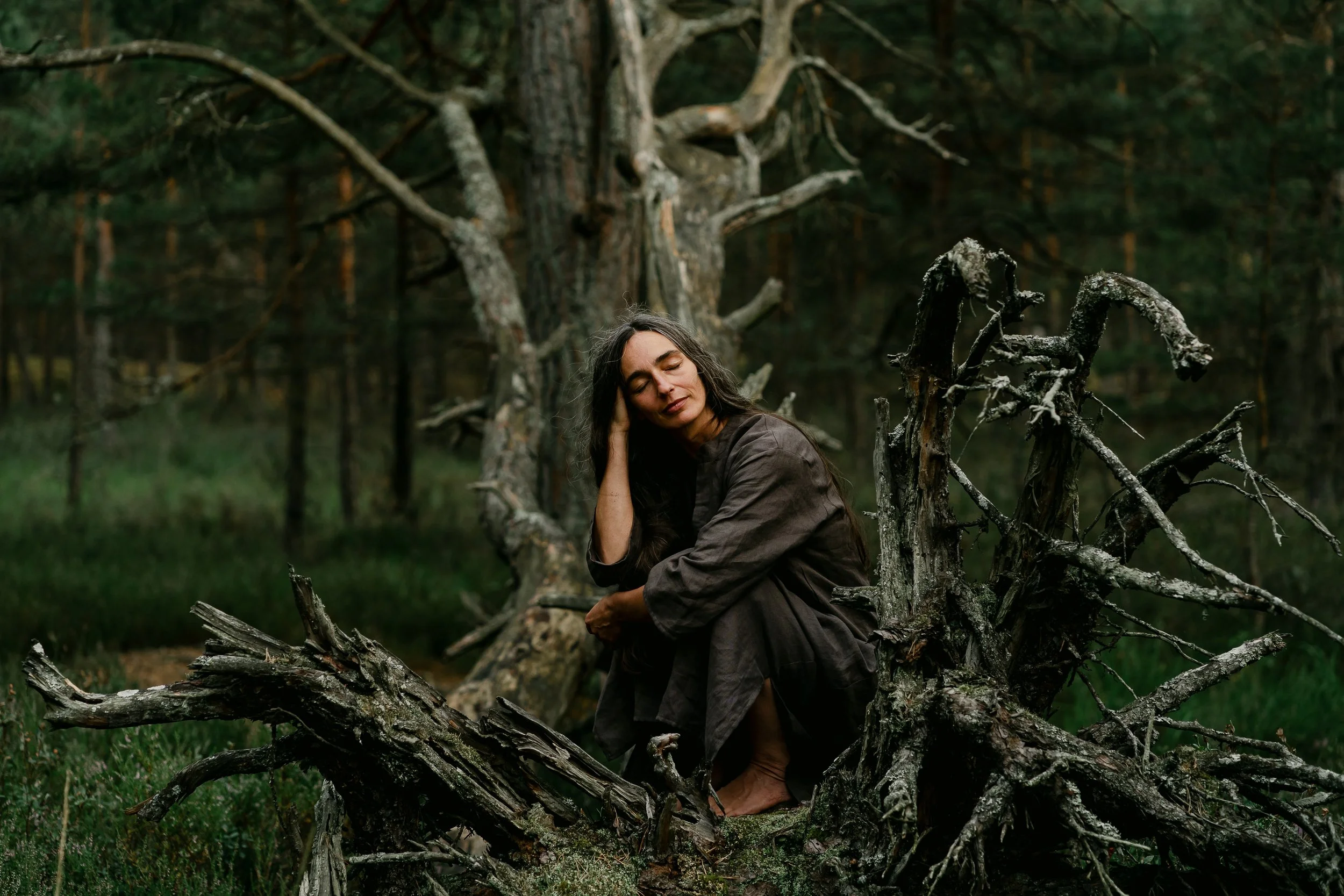 sound healer photographed on a large fallen tree