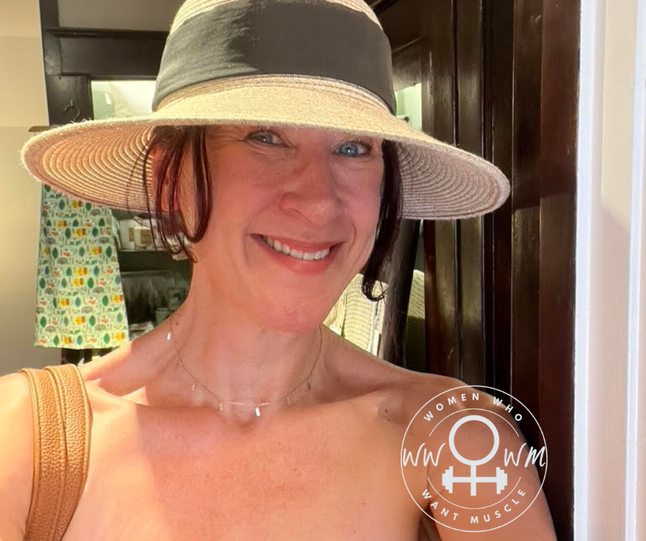 Woman in straw hat smiling at the camera.