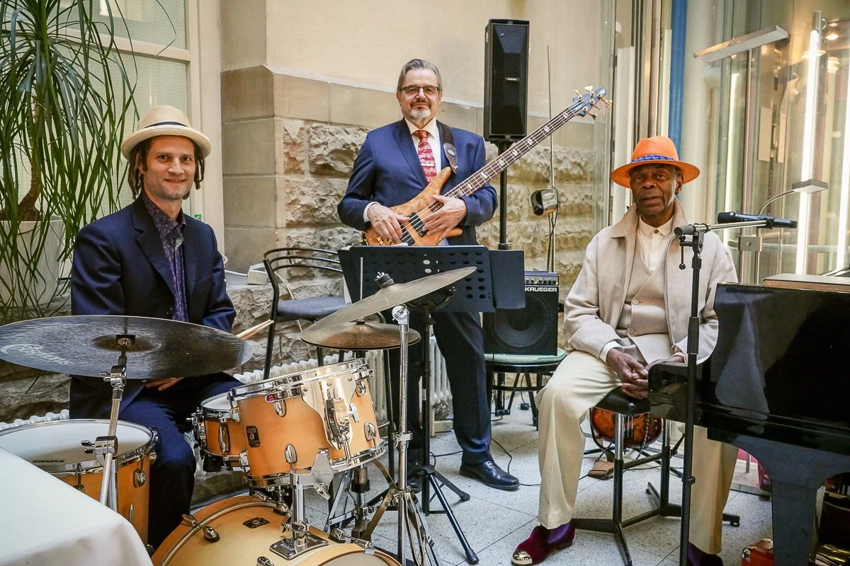 Drei Musiker sind vor ihren Instrumenten zu sehen