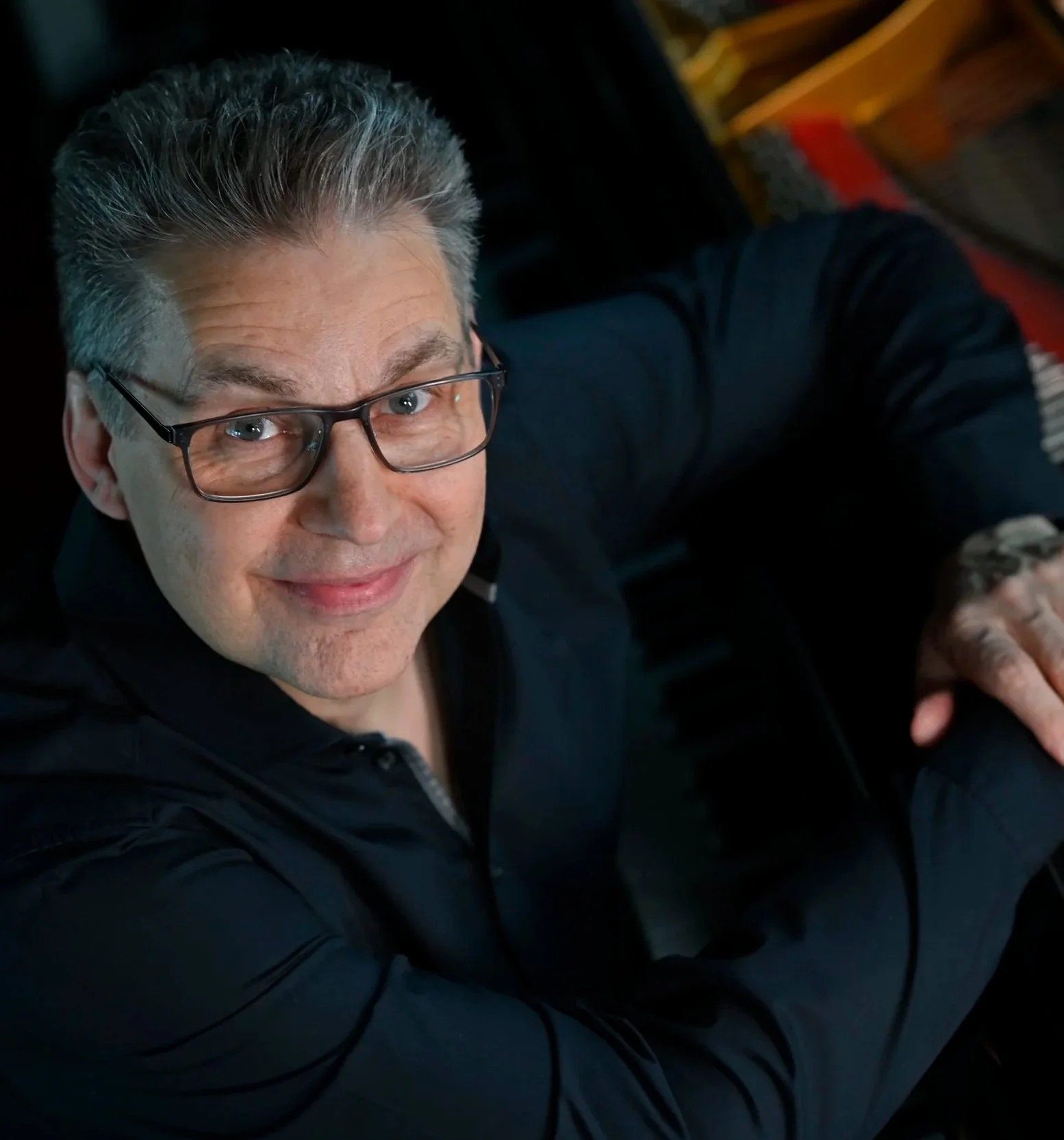 Ein Mann mit Brille lächelt freundlich in die Kamera.