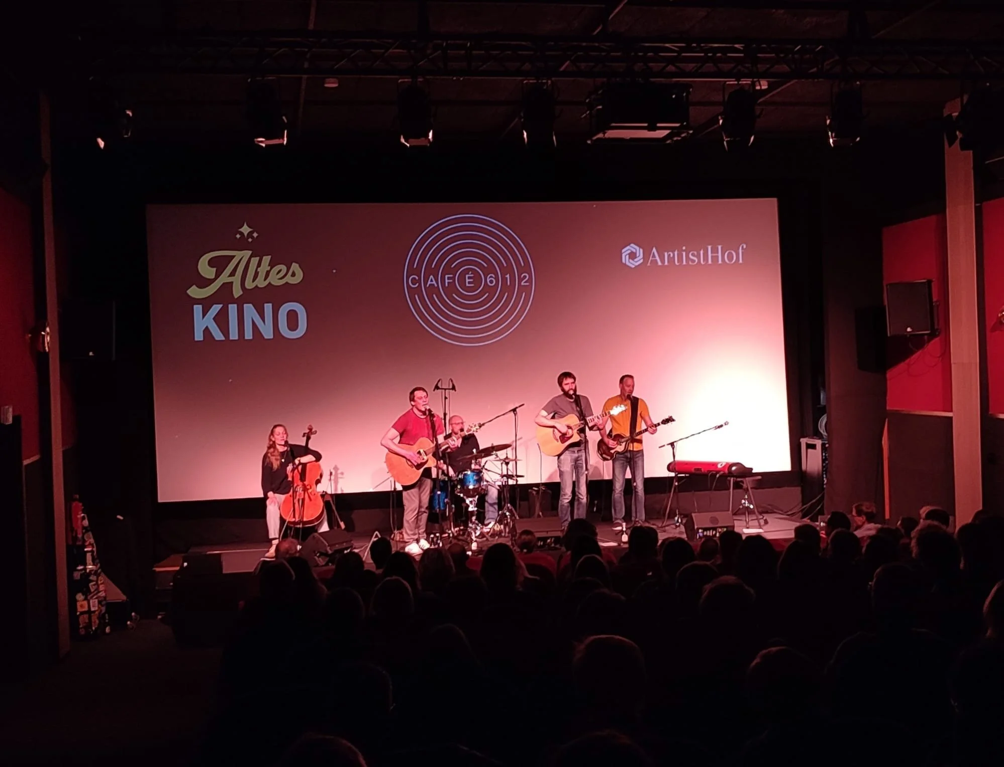 Eine Band steht auf einer Bühne und macht Musik