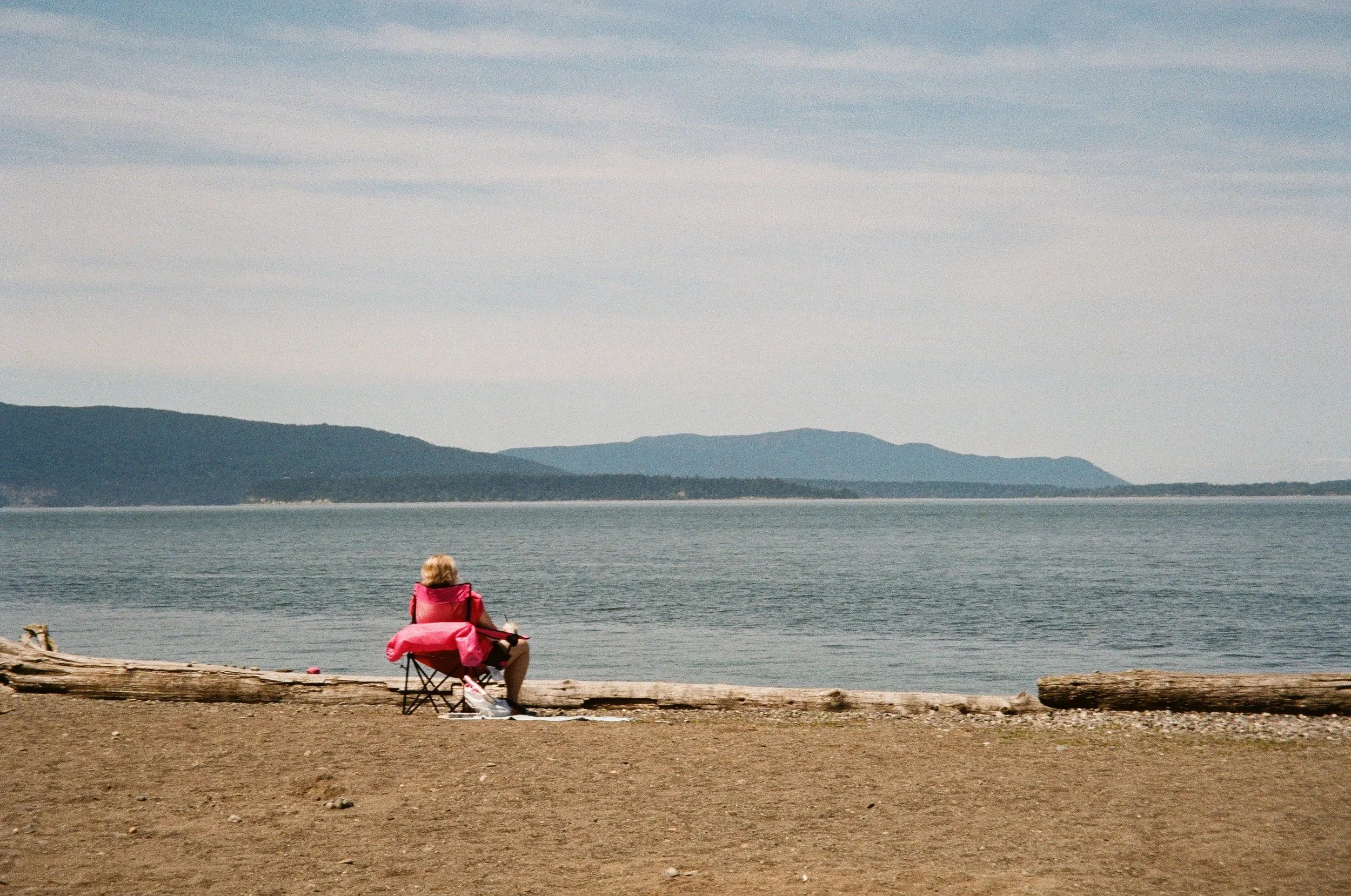 A woman sits in a beach chair overlooking Bellingham Bay at Boulevard Park in Bellingham, Wash.