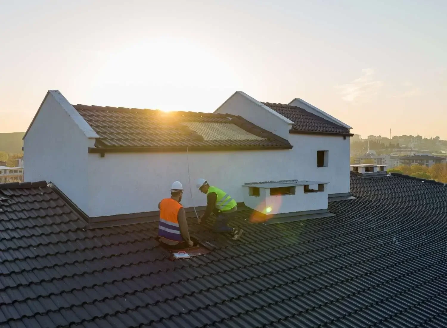 Two roofing experts working on a roof