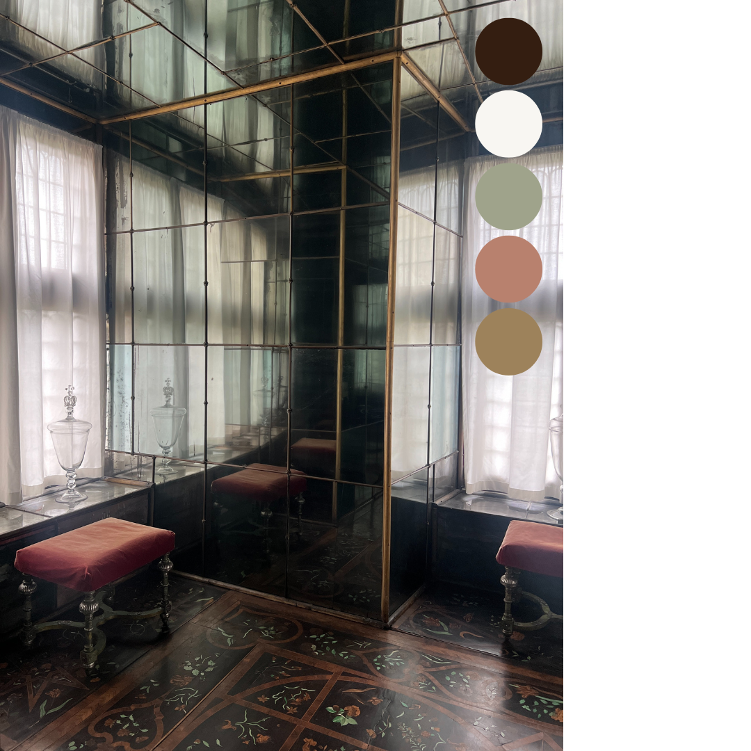 A vintage interior room with large windows with white curtains, ornamental glass jars on a side table, and a mirror divider with a reflective surface. Two upholstered stools with wooden legs are positioned on a dark, decorated wooden floor.
