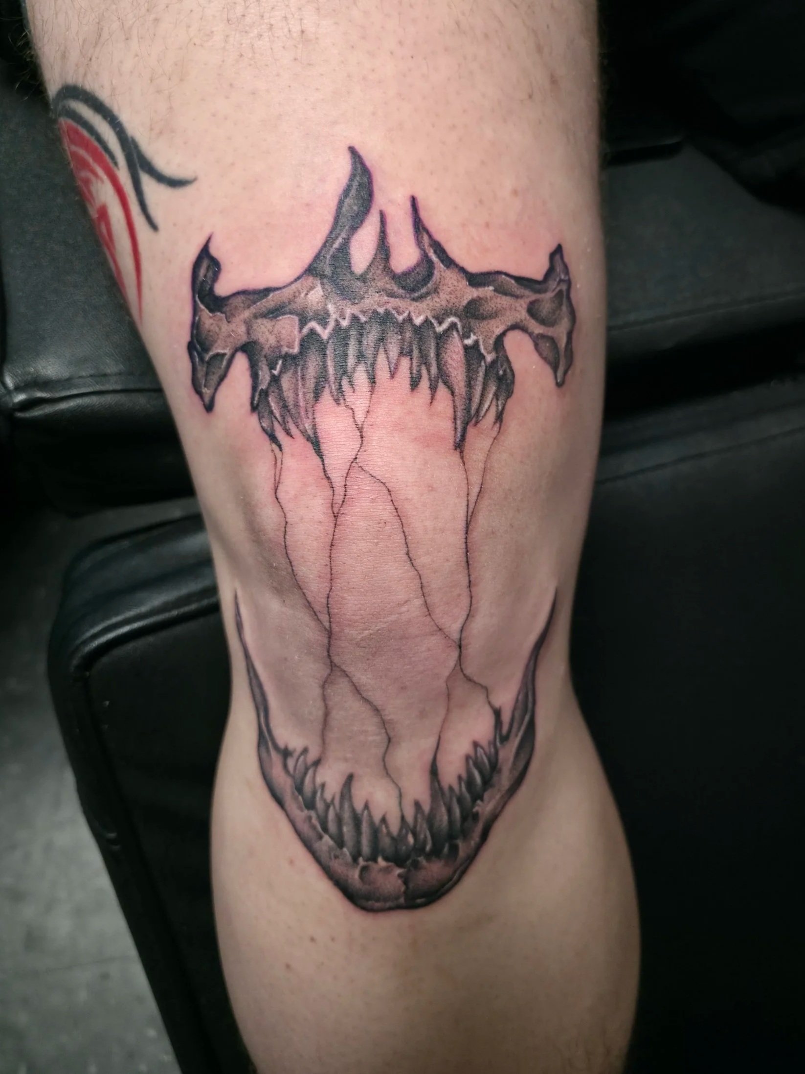 Tattoo of a bat skull on a person's thigh.