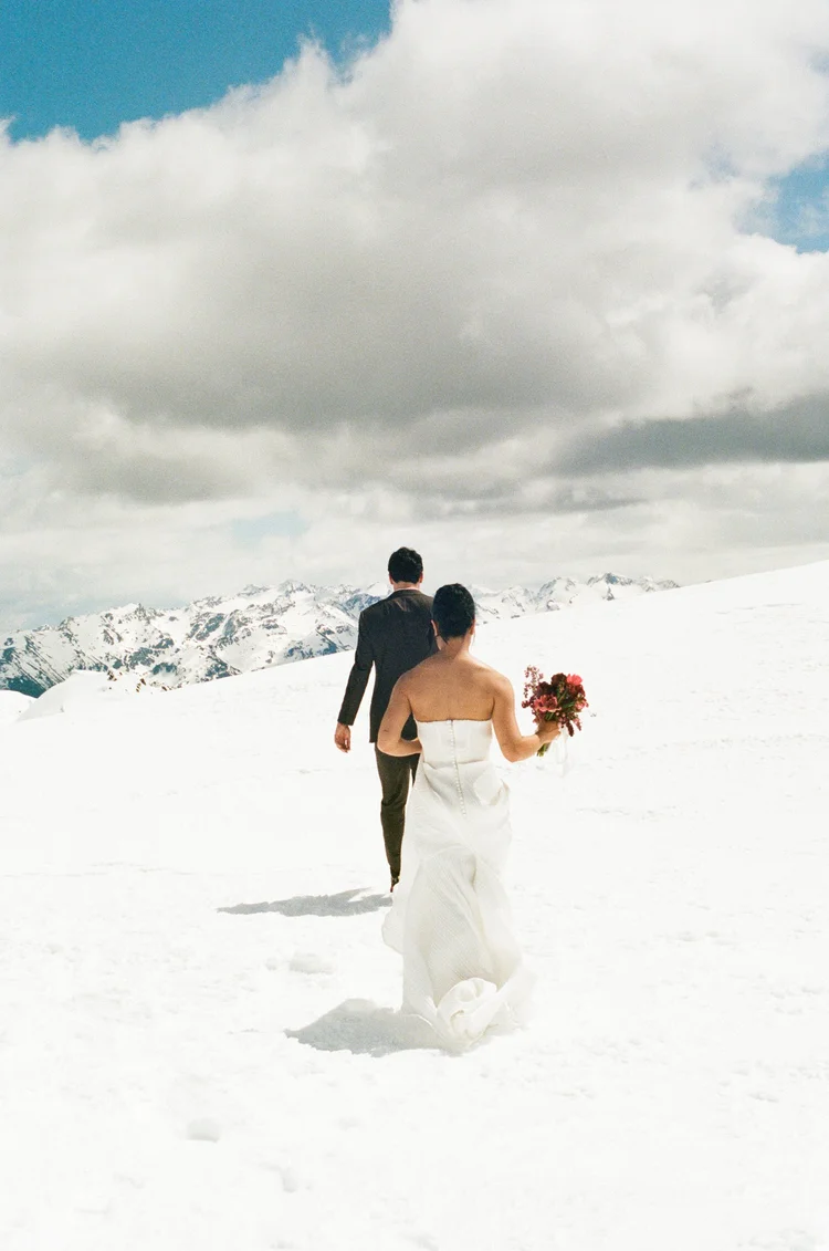 A couple walking across a snowy summit, photographed on 35mm film
