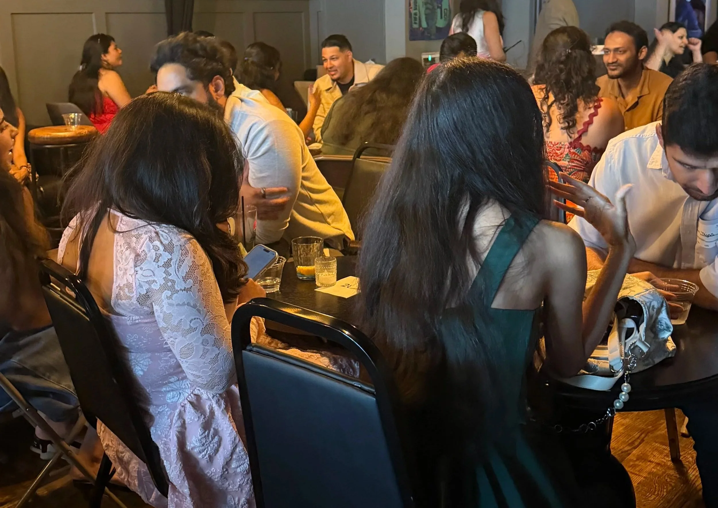South Asian singles talking across a table during a speed dating event in New York City