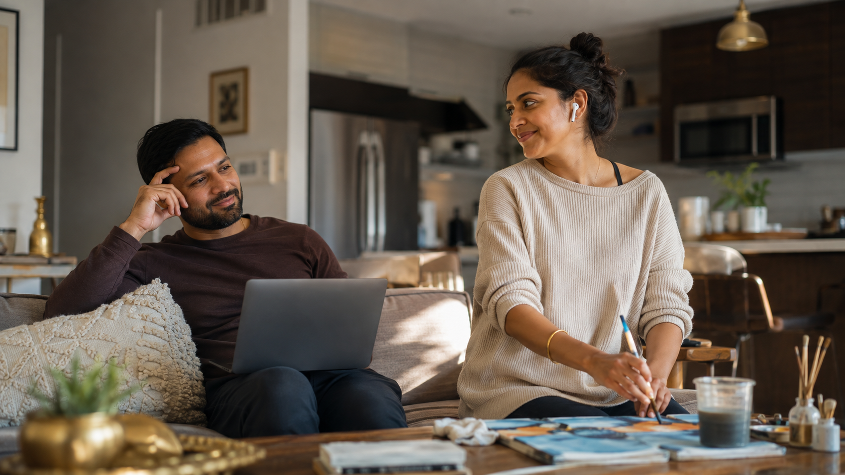 South Asian American couple relaxing together at home while enjoying separate activities.
