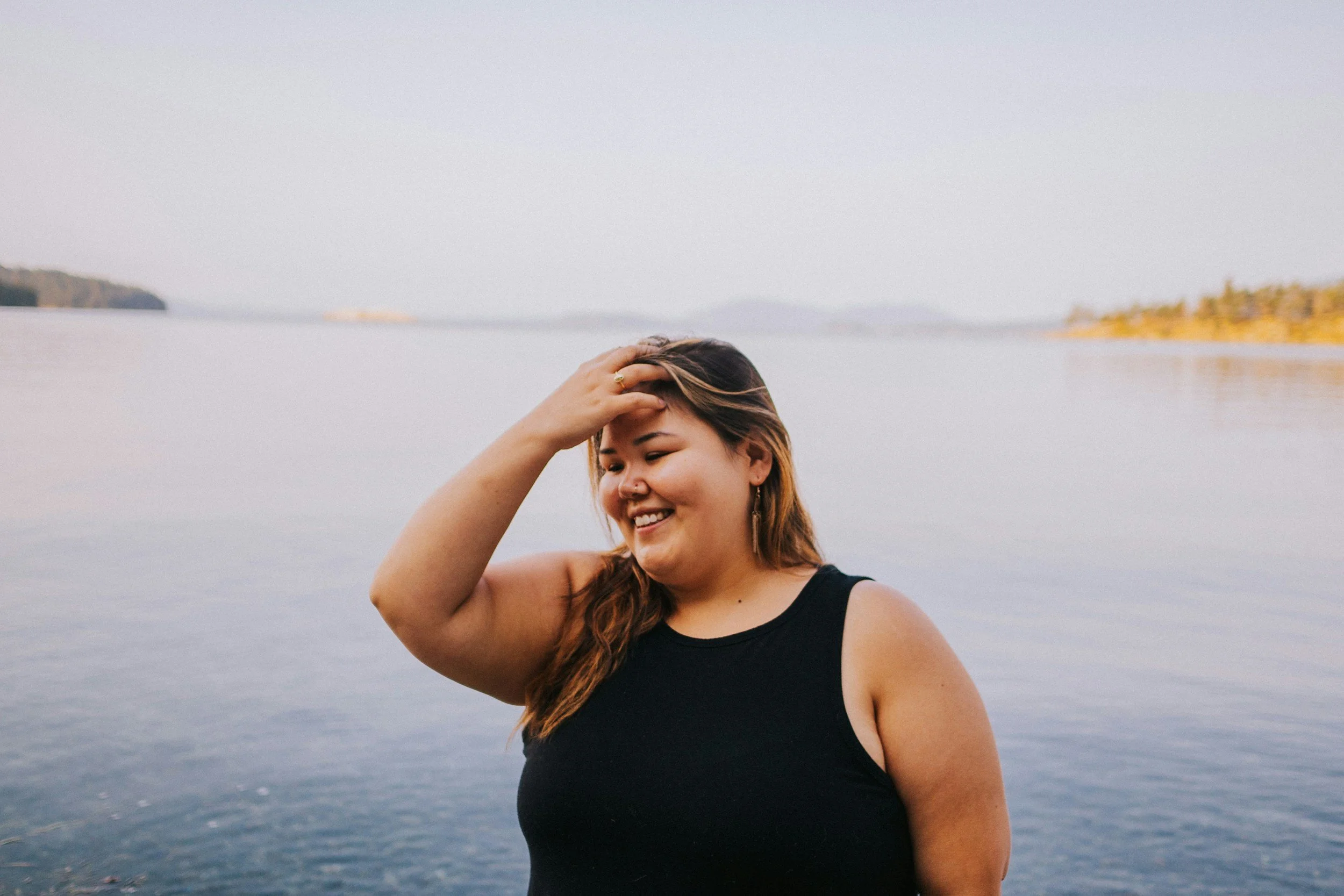 woman with a big smile with an ocean in the background
