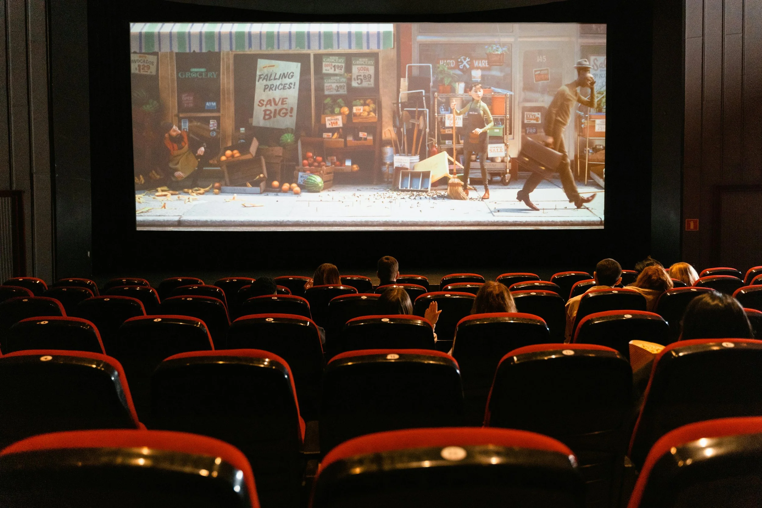 People sitting in a movie theater watching an animated film.