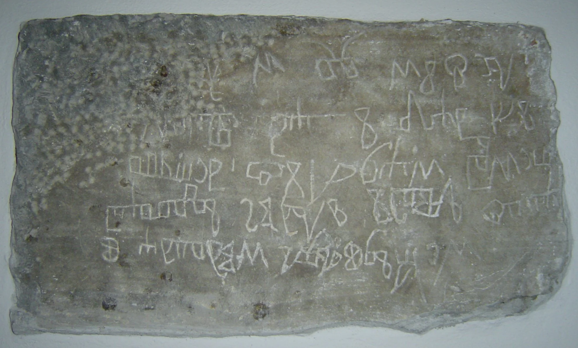 Ancient stone tablet with engraved inscriptions and symbols
