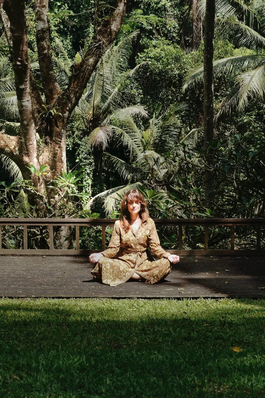 A person meditating in the garden with calm surroundings