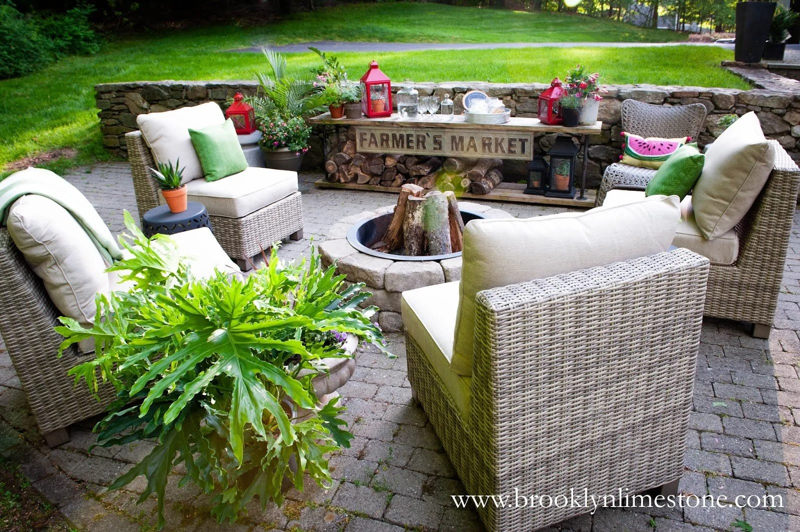 Outdoor patio with wicker furniture, fire pit, and decorative plants