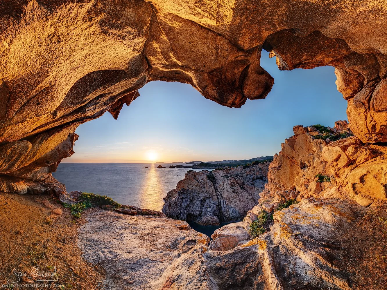 Award-winning fine art landscape panorama titled "Window to the World." A breathtaking sunset viewed through a natural sea cave on the Sardinian coast. Captured by Jan Smid, Master QEP, during a 2019 photography expedition. Masterpiece.