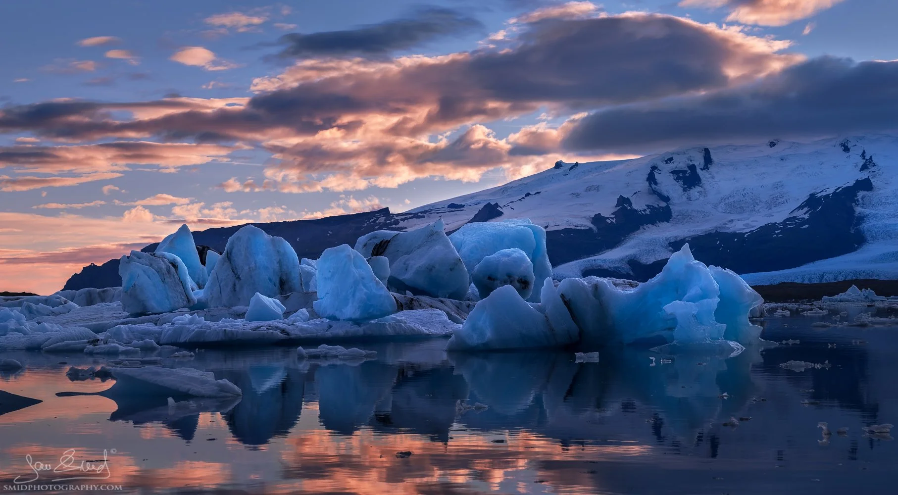 Artistic landscape panorama titled "Ice Fashion Show." Unique ice formations drifting in Jökulsárlón glacier lagoon, Iceland. Captured by Jan Smid, Master QEP, during a 2015 photo expedition. Blue ice textures and Arctic atmosphere.