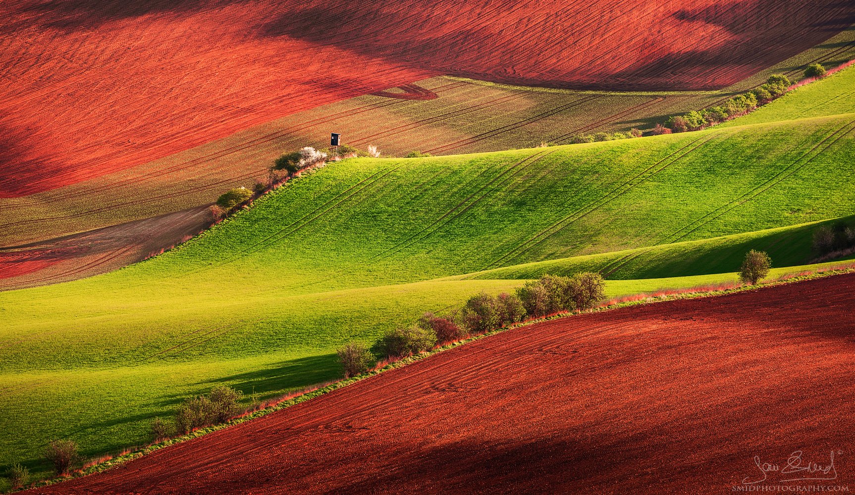 Spring Ski Slope in South Moravia, green and red rolling hills landscape, photography workshop by Jan Smid.