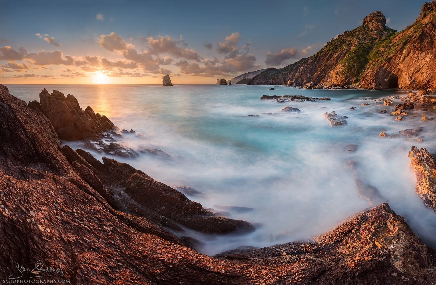 Award-winning fine art landscape panorama titled "Turquoise Sardinia." A dramatic sunset over the rugged red cliffs and turquoise waters of the Sardinian coast. Captured by Jan Smid, Master QEP, during a 2019 photography expedition.