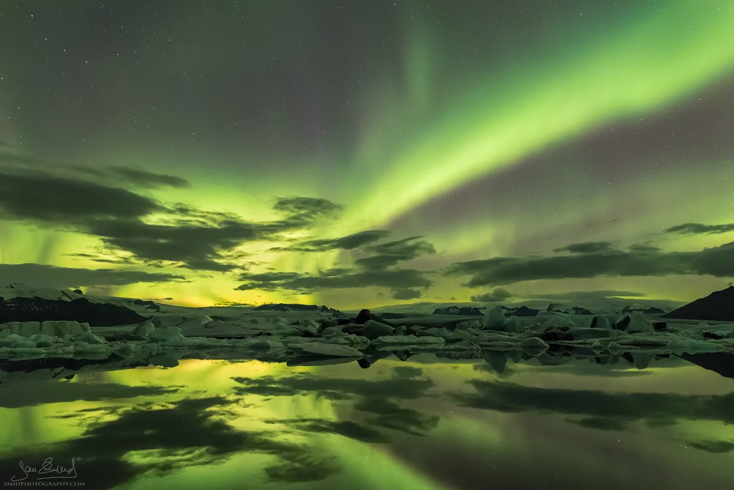 Massive night panorama titled "Green World" with intense Aurora Borealis reflecting in Jökulsárlón glacier lagoon, Iceland. Captured by Jan Smid, Master QEP, during a 2015 photo expedition. Immersive Northern Lights experience.