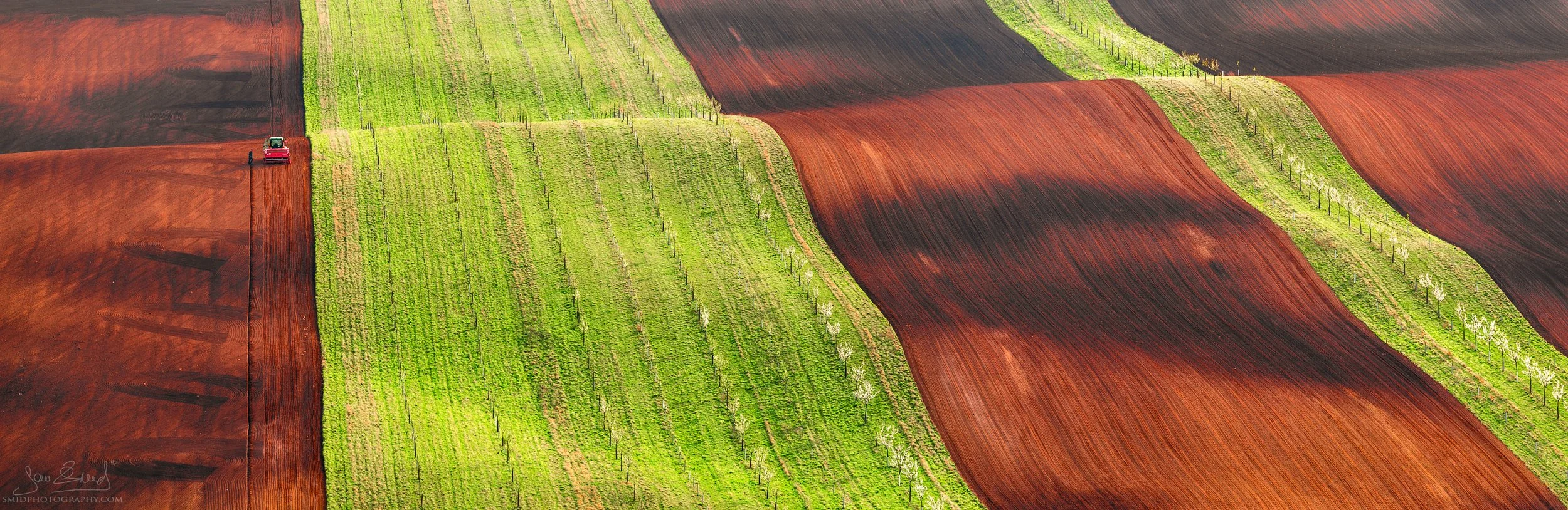 Award-winning telephoto landscape of a tractor working in the rolling fields of South Moravia, titled The Hard Work of the Tractor Driver Ciprian, by Jan Smid, Master QEP.