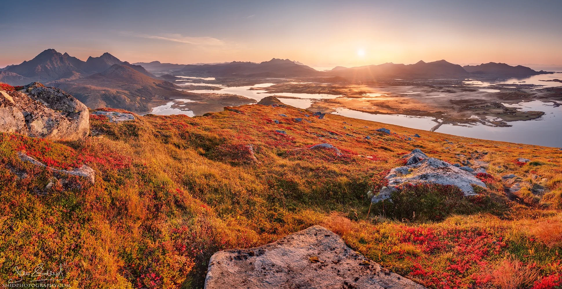 Panoramic sunrise photograph "Red Carpet" showcasing vibrant red autumn vegetation in the Lofoten mountains. Captured by Jan Smid, Master QEP, in 2017.