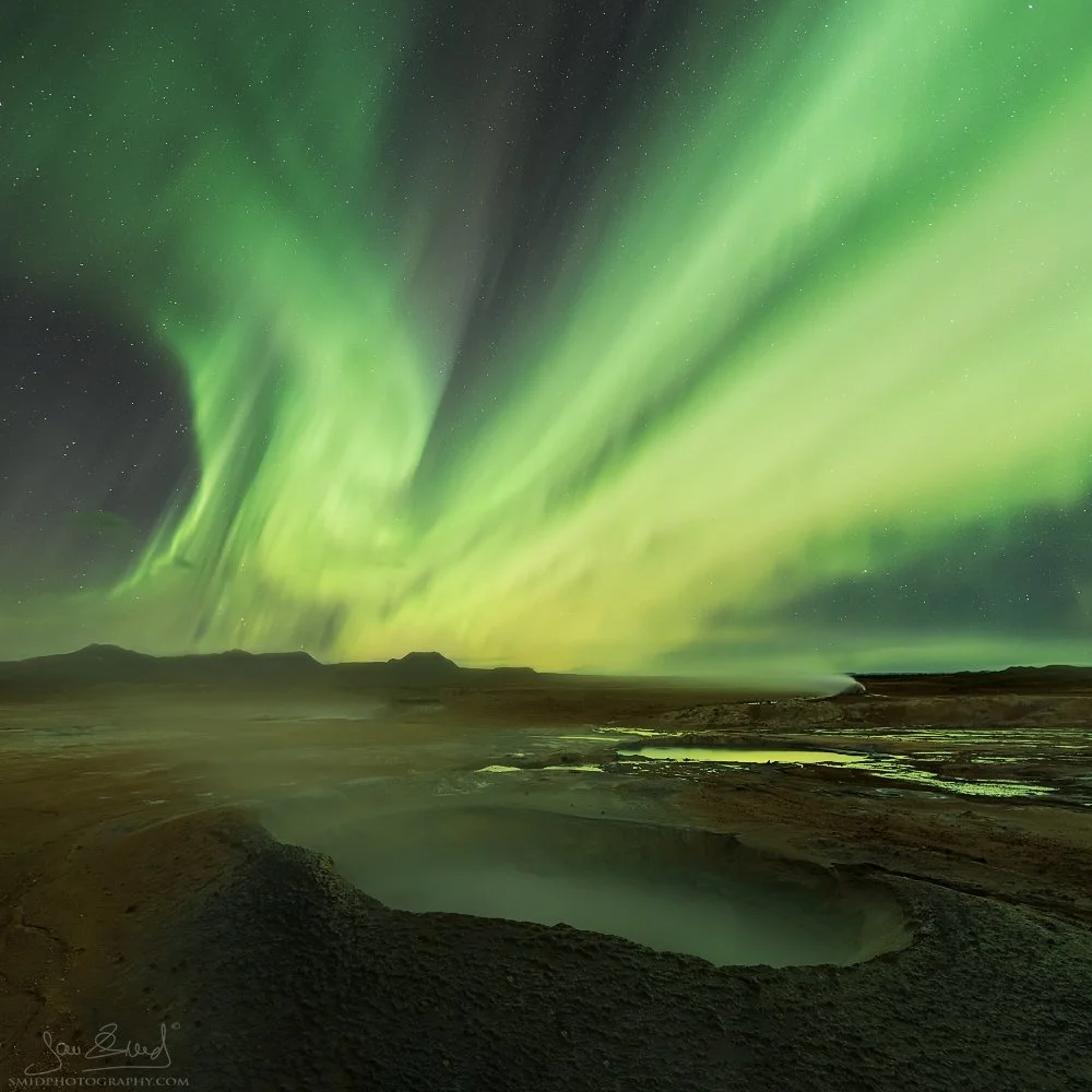 Award-winning night landscape titled "Sulfur Spirits." Green Northern Lights (Aurora Borealis) dancing over the Hverir geothermal mud pools, Mývatn, Iceland. Captured by Jan Smid, Master QEP, during a 2016 photo expedition. Iconic masterpiece.