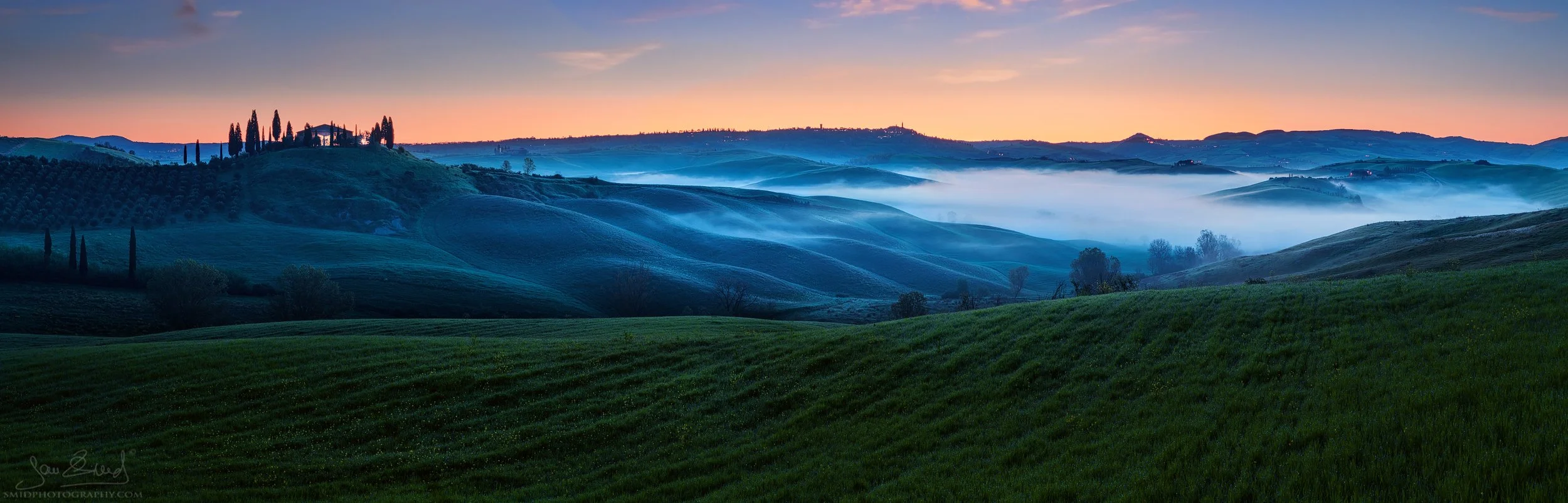 Dawn's Mist: 2023 pre-sunrise panorama of Podere Belvedere shrouded in blue hour mist. 45-frame masterpiece by Jan Smid, Master QEP, scouting Tuscany since 2017.