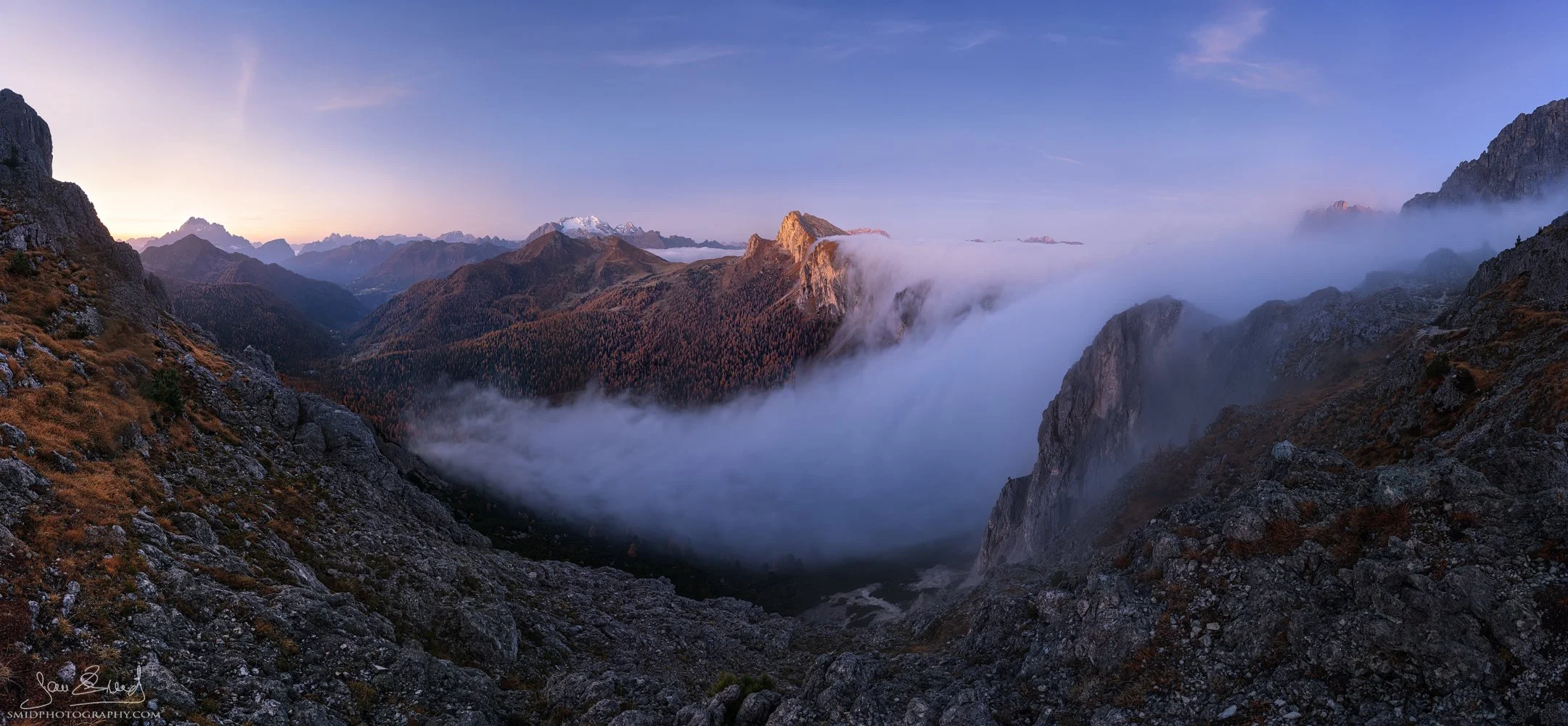 Fog cascading over mountain peaks titled "The Fog Fall" in the Dolomites by Jan Smid, Master QEP.