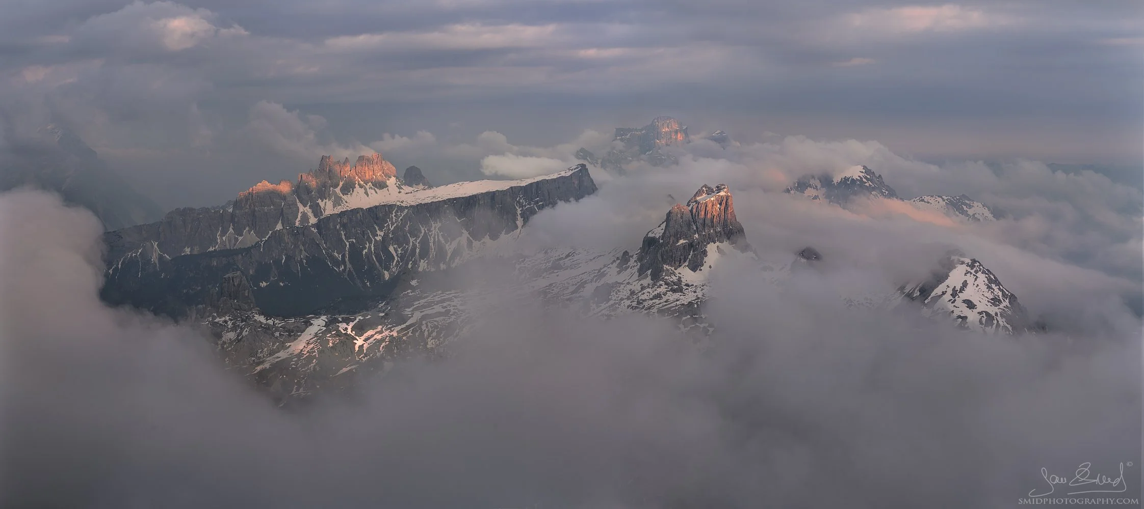 Summer panorama of Dolomite peaks rising through clouds at sunset by Jan Smid, Master QEP.