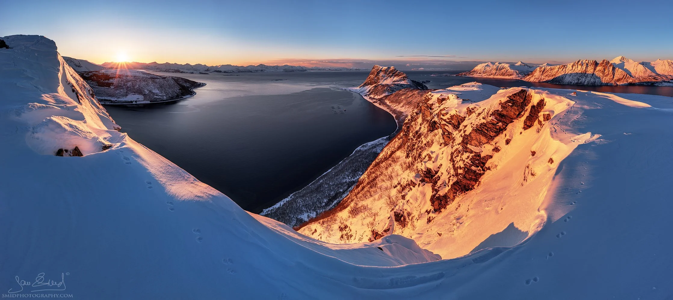 Panoramic landscape photograph "Following the Trail" featuring leading lines in the arctic snow towards the peaks of Lofoten. Captured by Jan Smid, Master QEP, in 2020.