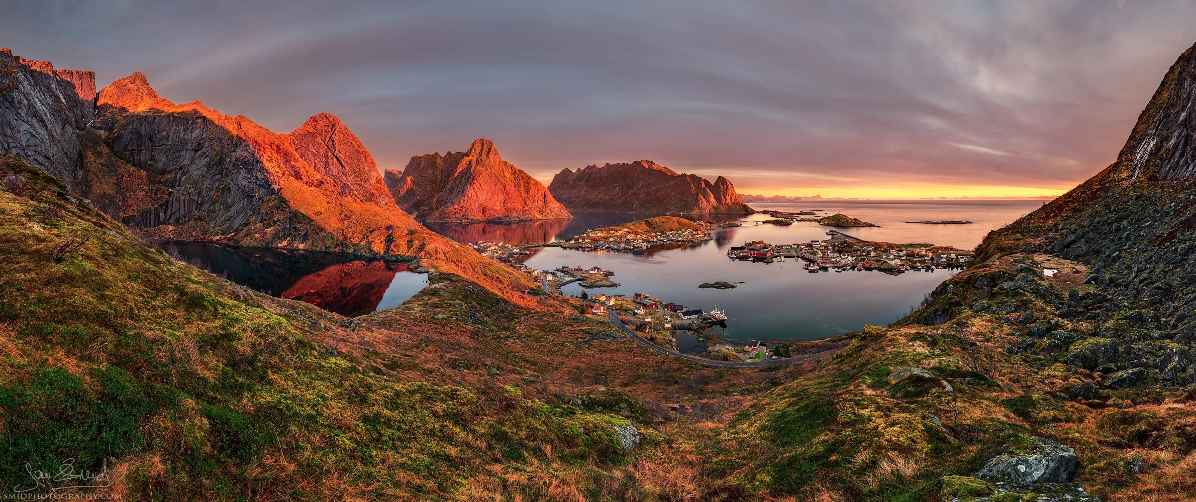 High-altitude panoramic photograph "Reine in November" showing the village of Reine from a unique, self-discovered vantage point. Captured by Jan Smid, Master QEP, in 2018.