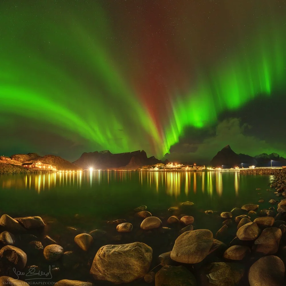Green-red aurora borealis over Reine village in Lofoten, Norway, photographed during strong wind conditions on the October 2024 photo expedition led by Jan Smid, Master QEP