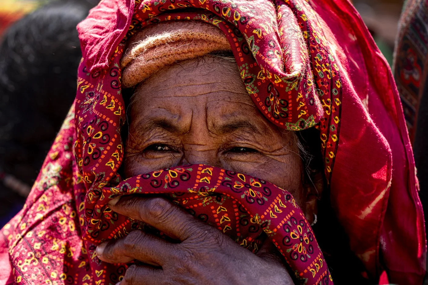 Ältere Frau in traditionellem rotem Kopftuch beim Sani-Fest in Zanskar