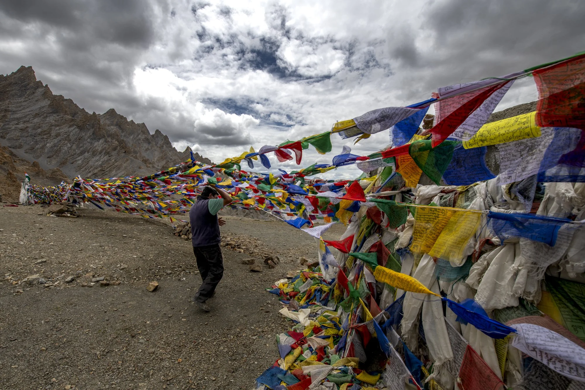 Auf dem Singey La wird eine neue Schnur Gebetsfahnen gespannt, Ladakh