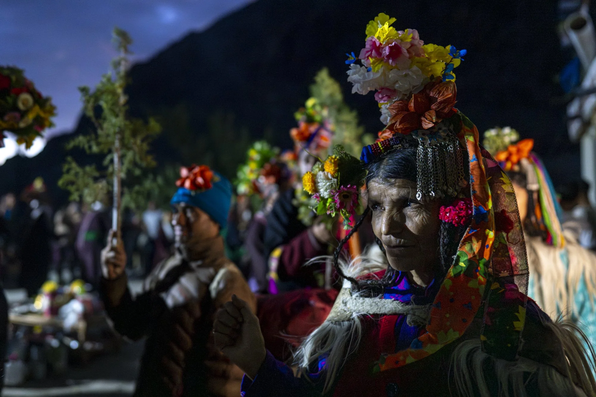 Brokpa mit Blumenkopfschmuck, Silberschmuck und Fellumhang bei einem Fest im Aryan Valley, Ladakh