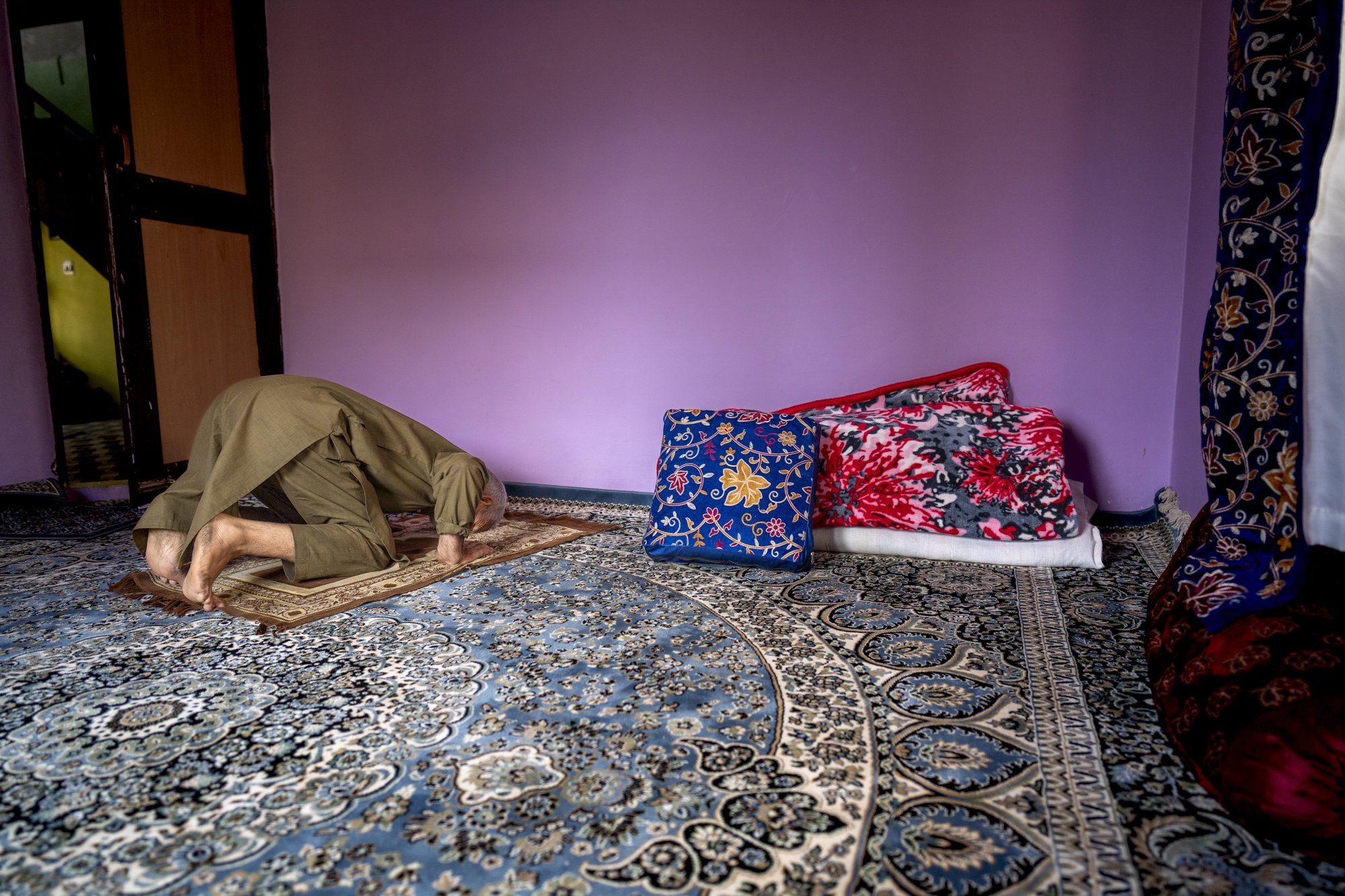 Älterer Mann im Gebet auf einem Teppich in einem Wohnraum, Sopore, Kaschmir
