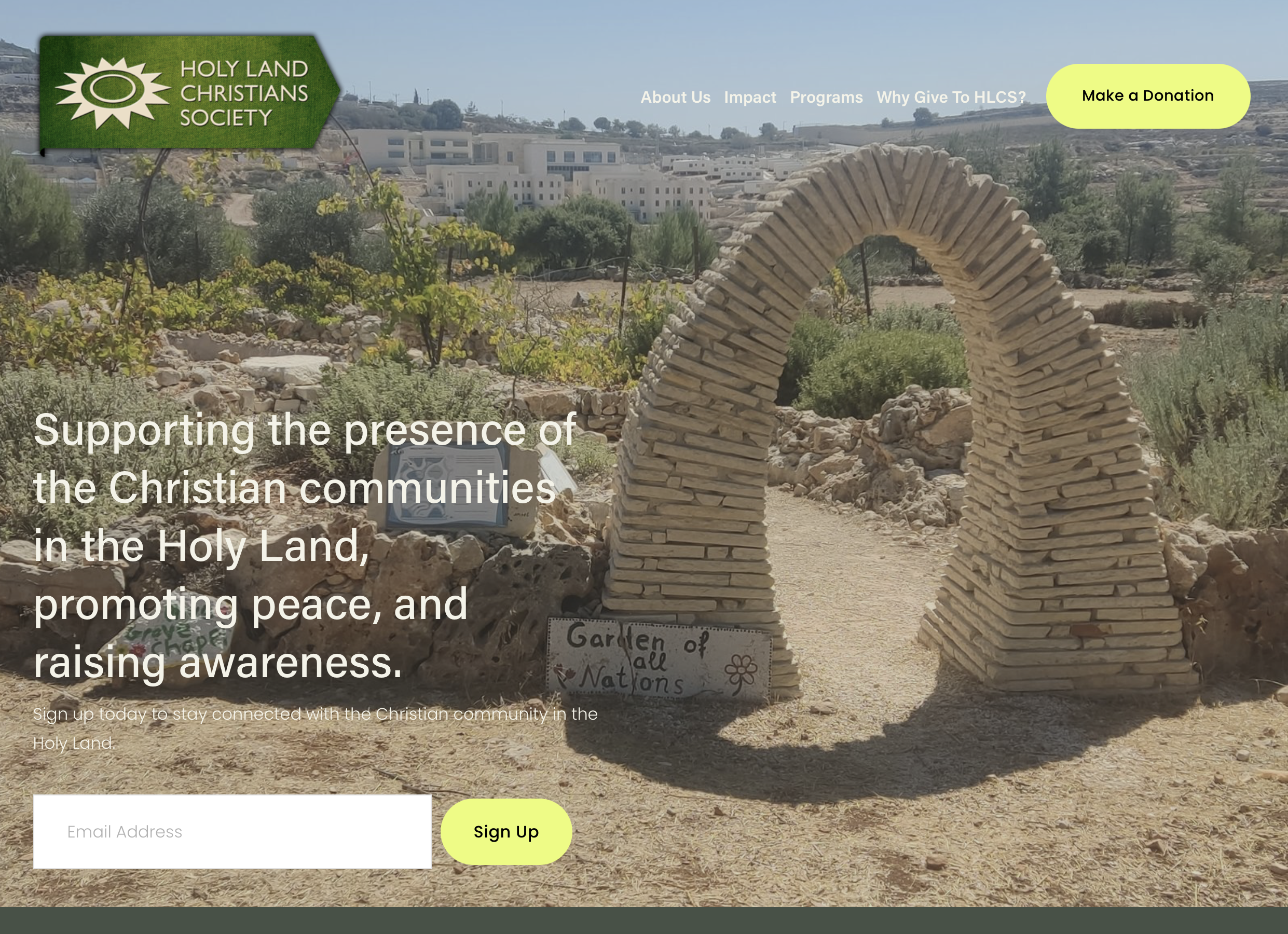 Website homepage of Holy Land Christians Society featuring a stone archway in a desert garden with plants and white buildings in the background. Includes a green logo, navigation menu, yellow donation button, and text about supporting Christian communities in the Holy Land.