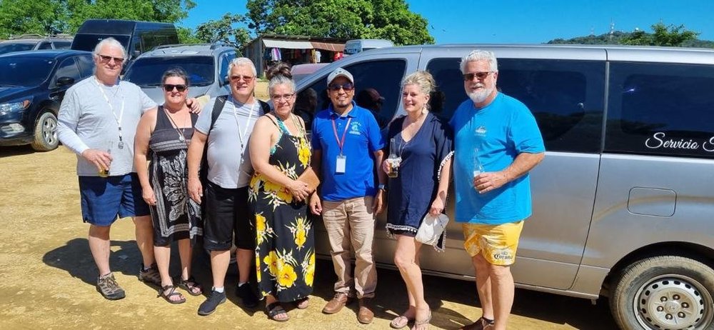 A smiling group with their private driver and van on Roatan