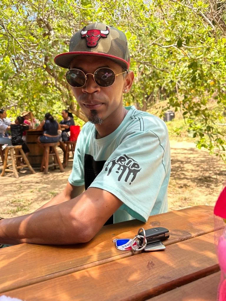 Edgart seated outdoors with his keys on the table