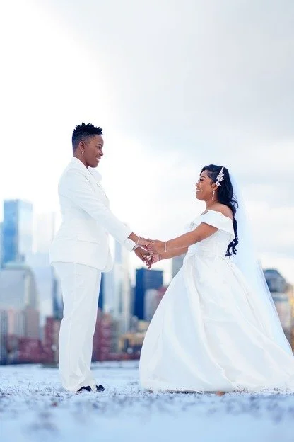 Same-sex couple portrait at Liberty State Park wedding with skyline view