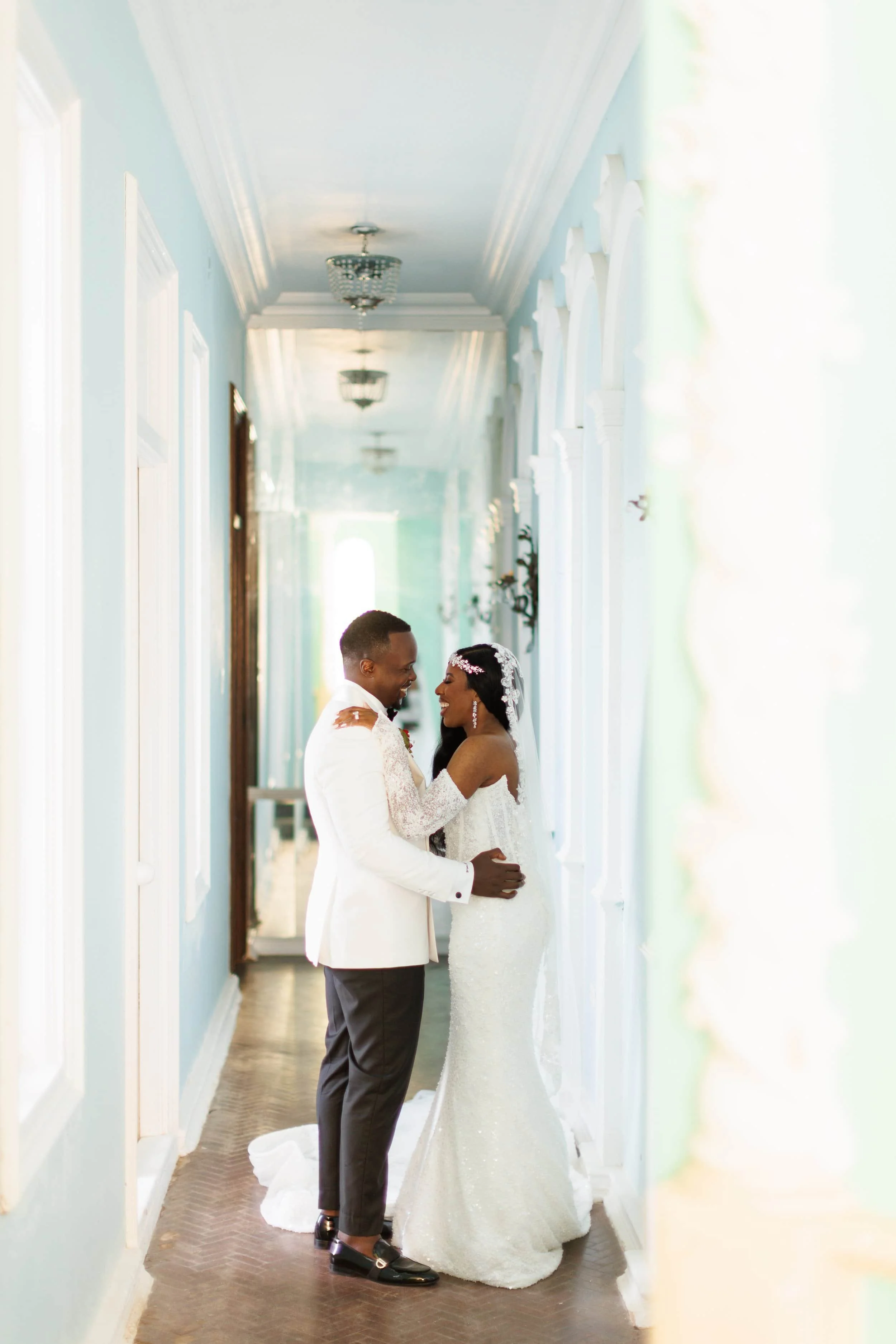 Trident Castle wedding couple embracing in elegant blue hallway with natural light in Jamaica