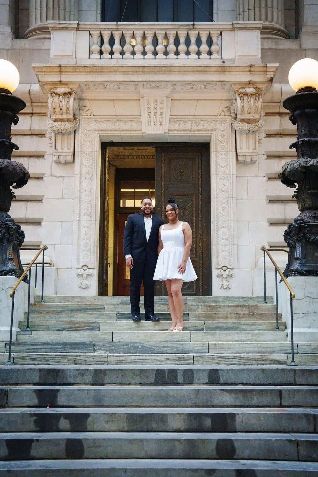 Newlywed couple standing on steps of New York Public Library after NYC City Hall wedding ceremony in Manhattan